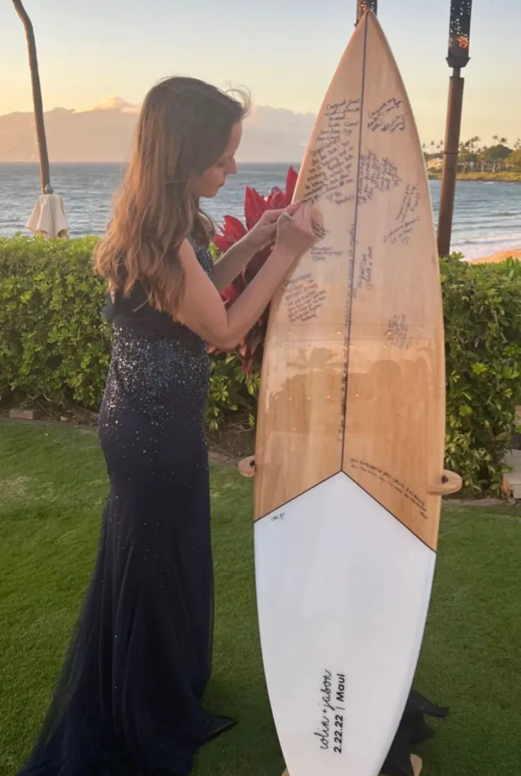 une femme qui signe une planche de surf