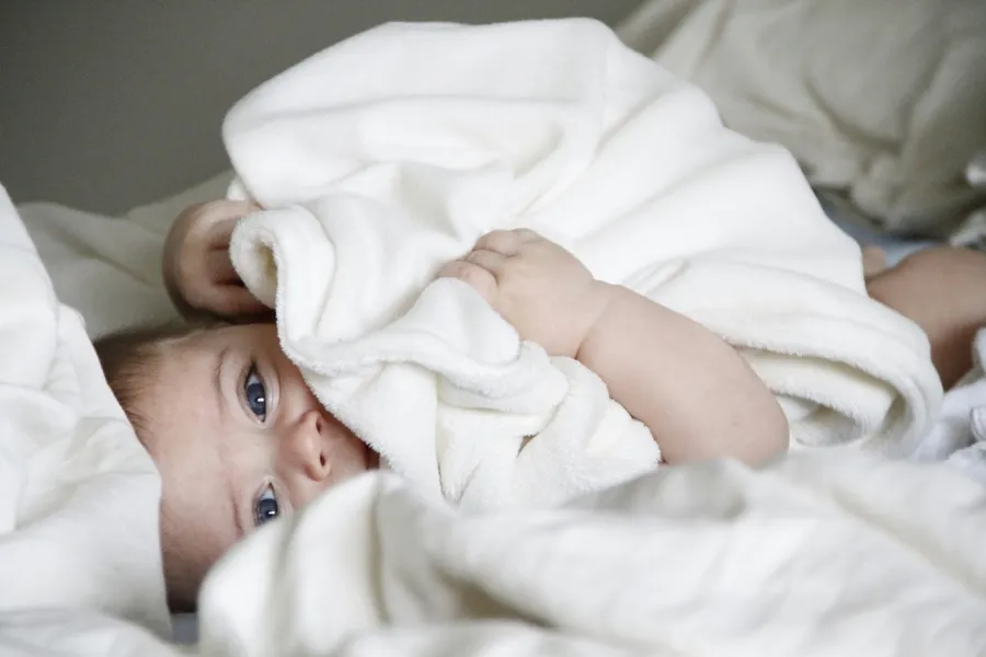 petit bébé que l'on essuie après le baptême