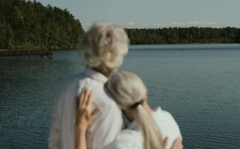 un couple de retraités qui regarde un lac au loin