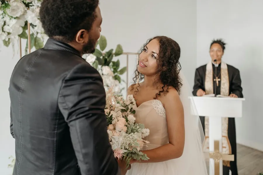 un marié et une mariée se tenant la main, le marié prononce ses voeux de mariage à son épouse yeux dans les yeux