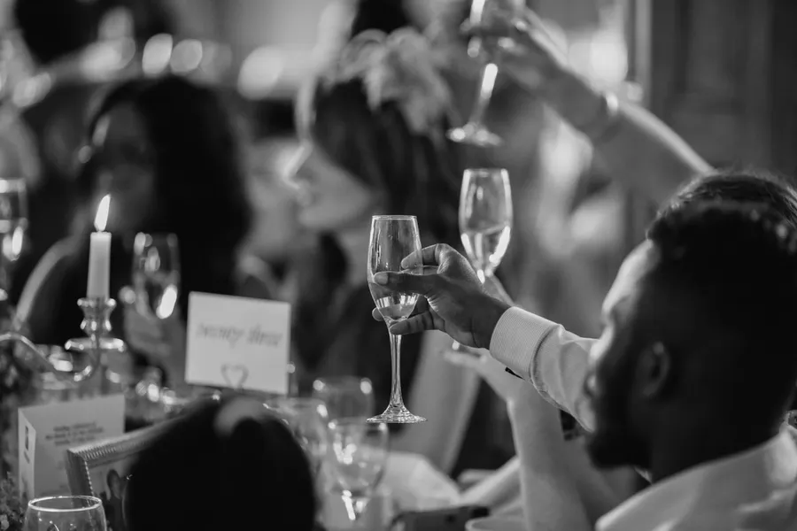 les invités lèvent leur verre pour porter un toast à un mariage