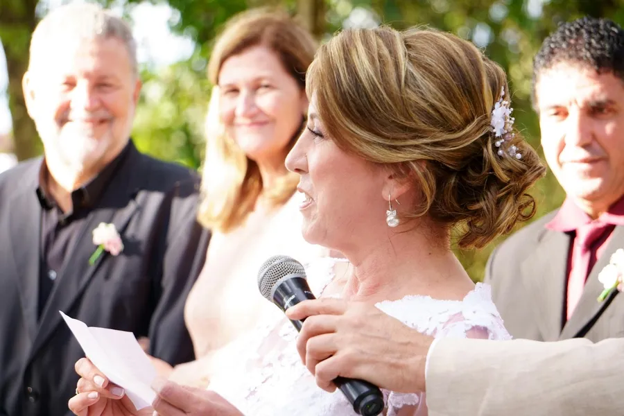 Une mère qui lit un discours avec un micro au mariage de sa fille