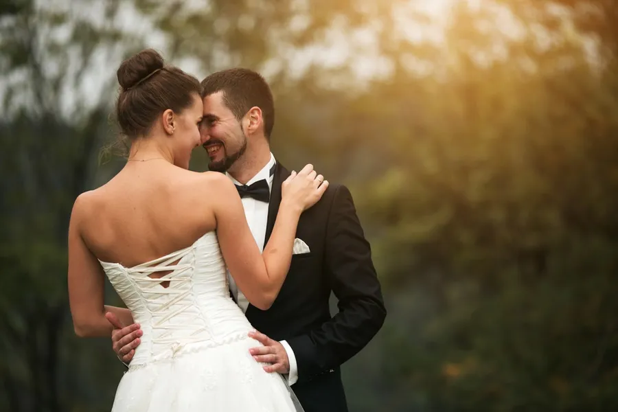 un couple de mariés heureux et souriant, front contre front