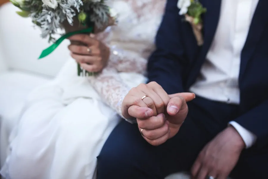 deux mariés qui se tiennent la main avec tendresse