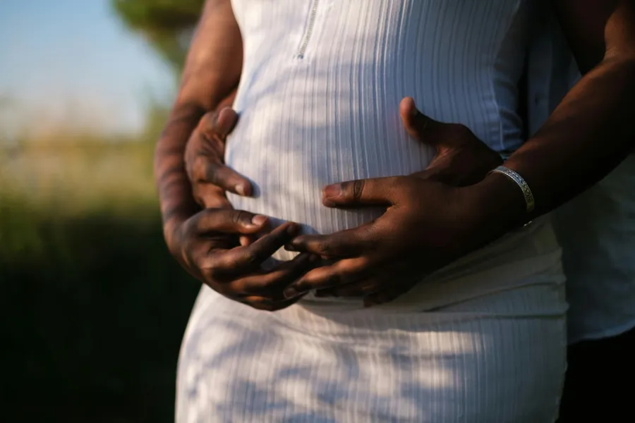 un couple qui tient le ventre de la femme enceinte