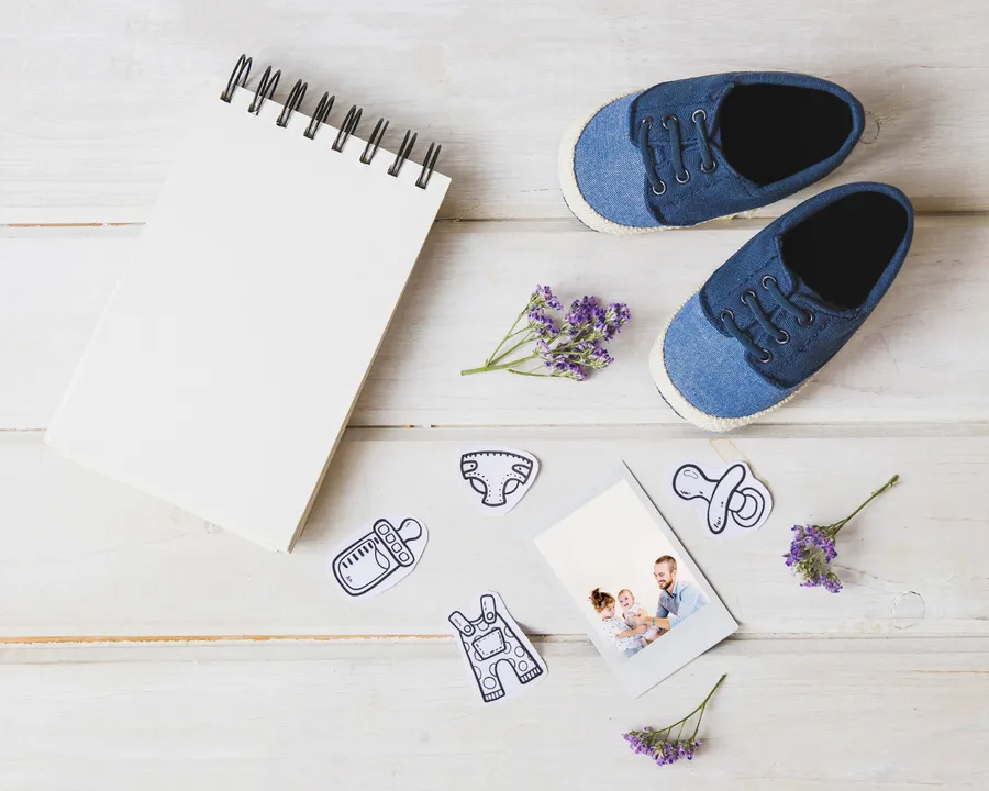 Carnet de note avec des chaussures d'enfant et des fleurs