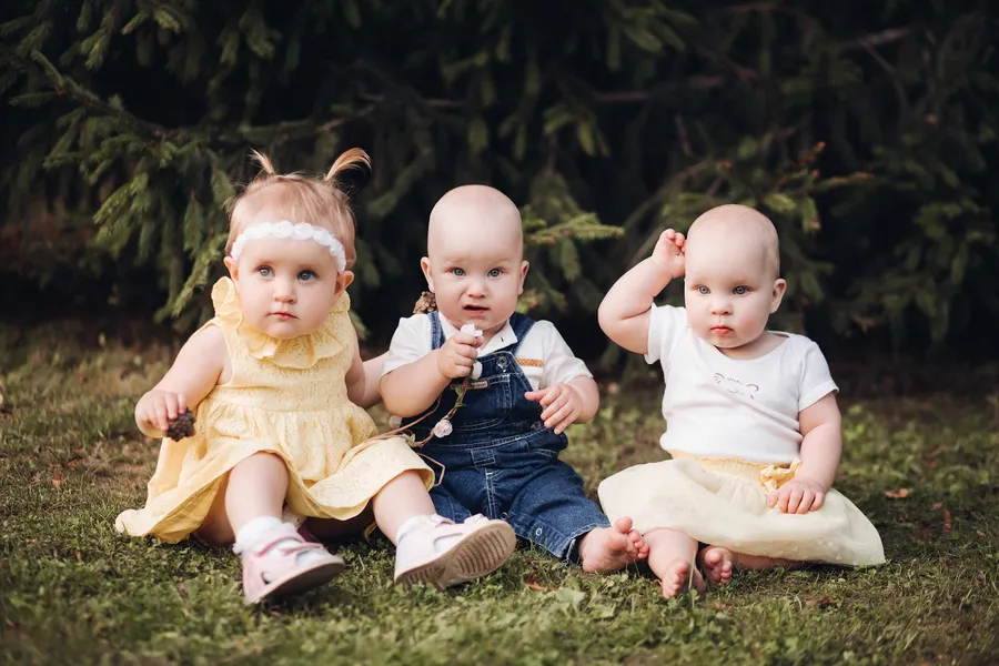 Trois enfants sur de l'herbe